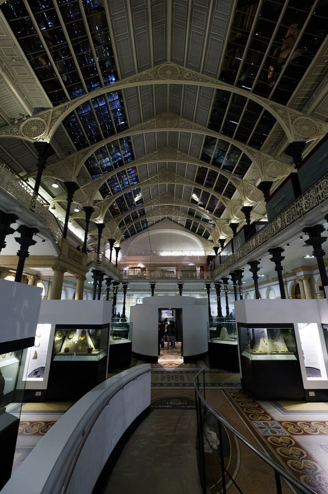 Modern exhibition hall displaying hypercars under dramatic lighting
