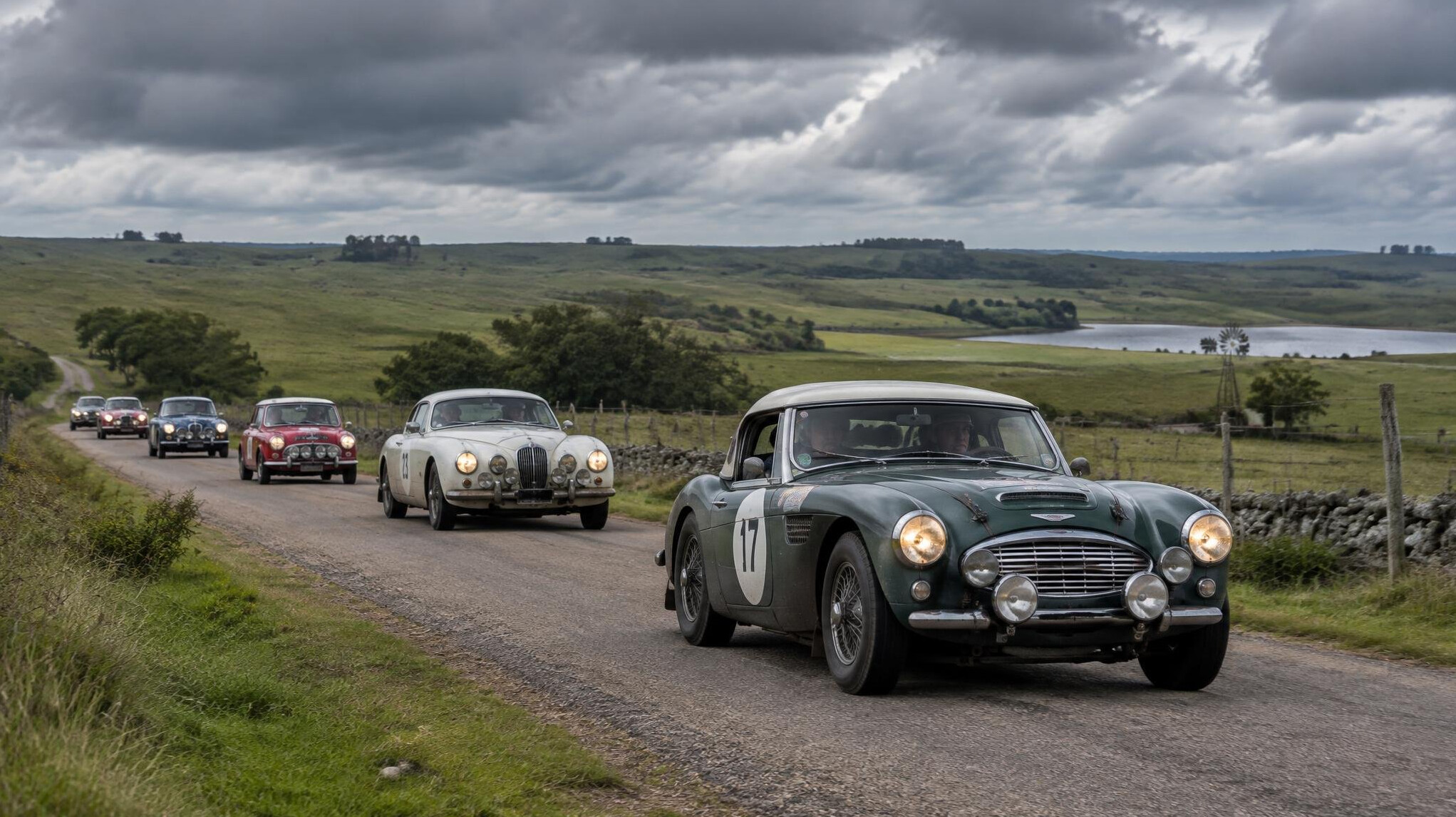 Line of classic rally cars driving through the Uruguayan countryside