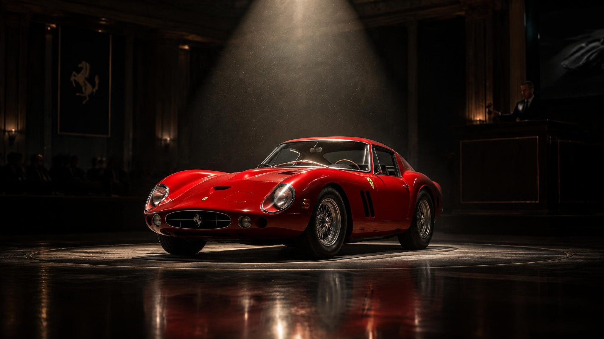 Red vintage Italian sports car spotlighted at an auction house